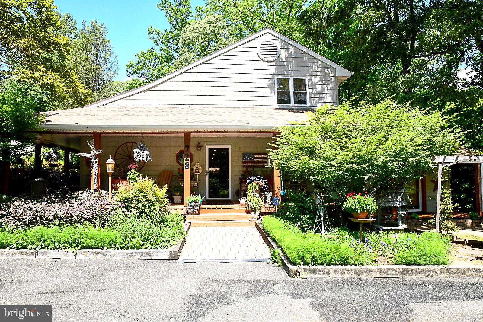 a front view of a house with a garden and plants