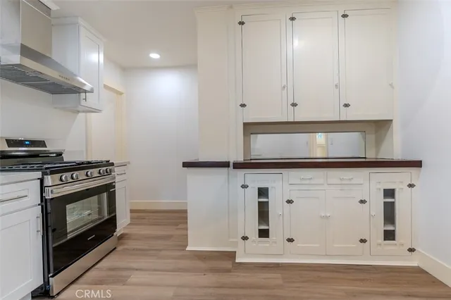 a kitchen with stainless steel appliances granite countertop a stove a microwave and white cabinets