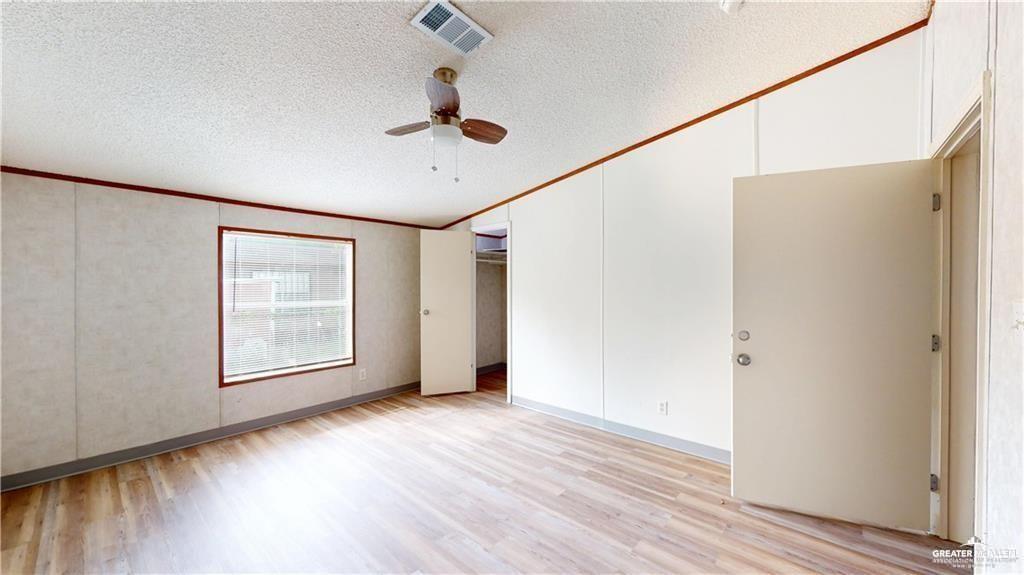 613 East Loop 19th Street Weslaco, TX 78596 - Photo 14 of 30 a view of an empty room with wooden floor and a window
