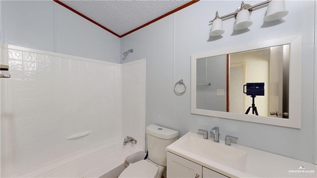 613 East Loop 19th Street Weslaco, TX 78596 - Photo 19 of 30 a bathroom with a toilet sink vanity and mirror