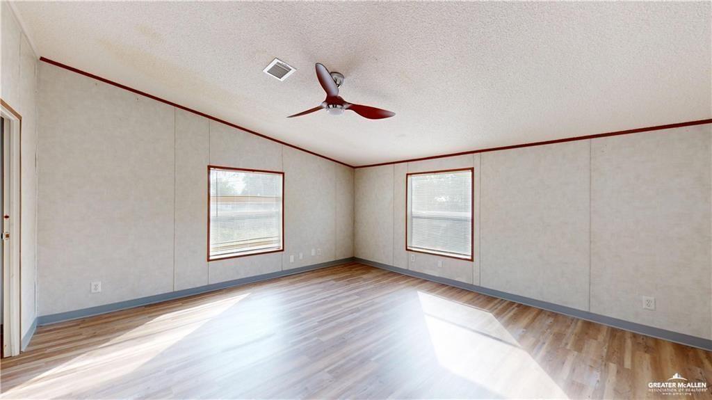 613 East Loop 19th Street Weslaco, TX 78596 - Photo 21 of 30 a view of an empty room with wooden floor and a window