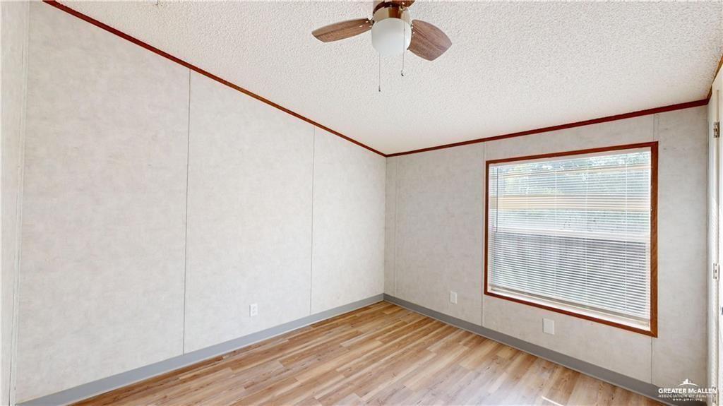613 East Loop 19th Street Weslaco, TX 78596 - Photo 25 of 30 a view of an empty room with a window and wooden floor