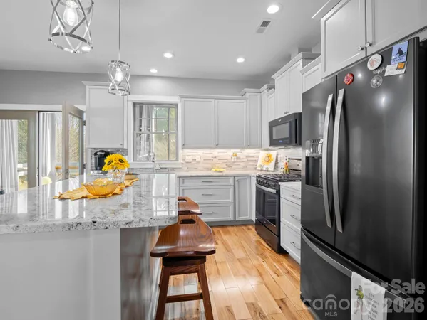 a kitchen with stainless steel appliances granite countertop a refrigerator and a stove
