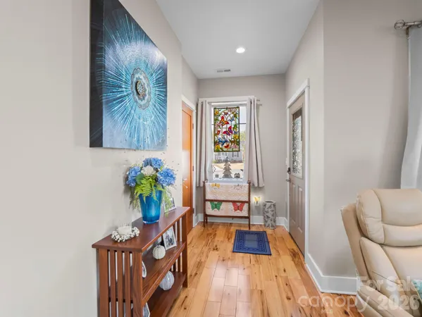 a view of a hallway with wooden floor and furniture