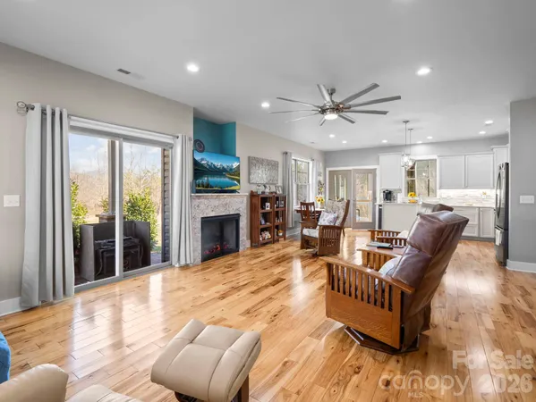 a living room with furniture a fireplace and a large window