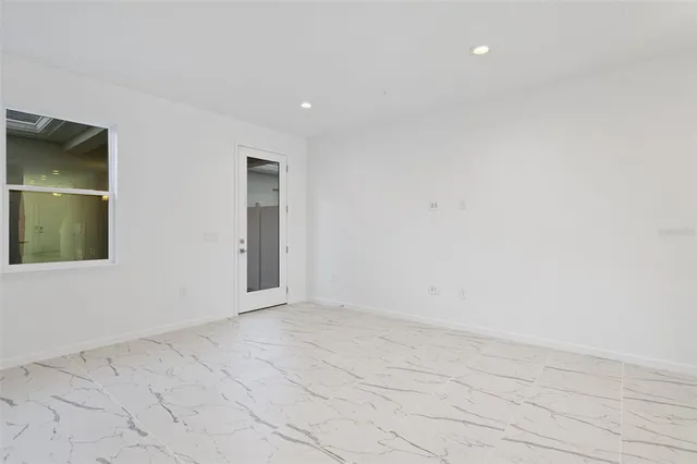 a view of kitchen with granite countertop cabinets and refrigerator