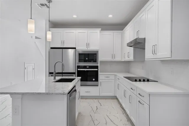 a kitchen with stainless steel appliances white cabinets and a refrigerator
