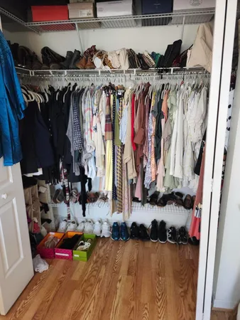 a view of walk in closet with clothes and shoes