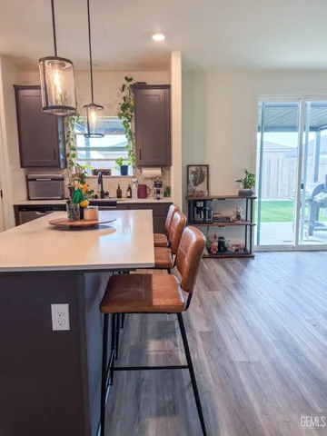 a kitchen with kitchen island a large counter top space appliances and wooden floor