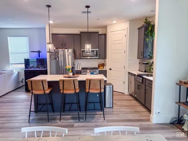 a kitchen with granite countertop a dining table chairs and refrigerator