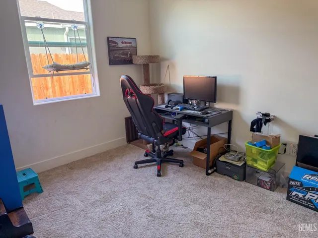 a view of a workspace with furniture and a window