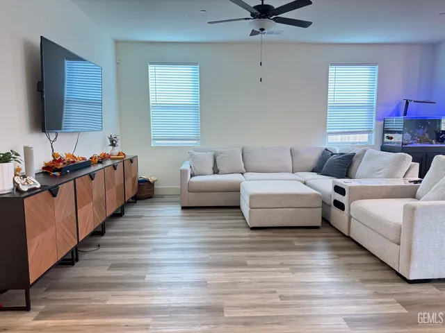 a living room with furniture hard wood floor and a flat screen tv