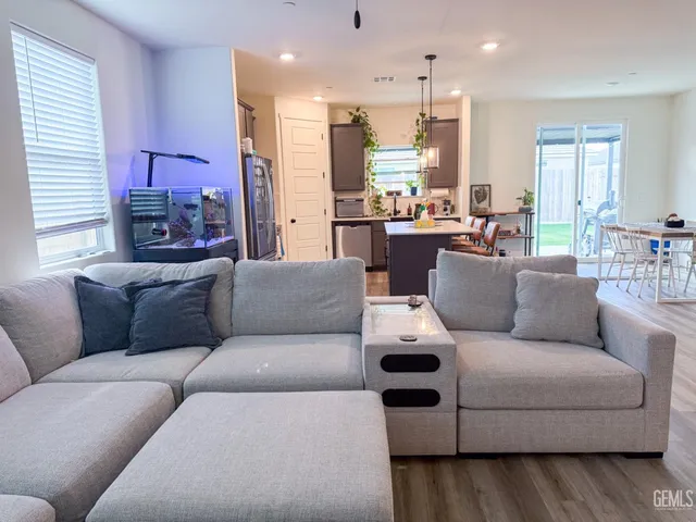 a living room with furniture and a view of kitchen