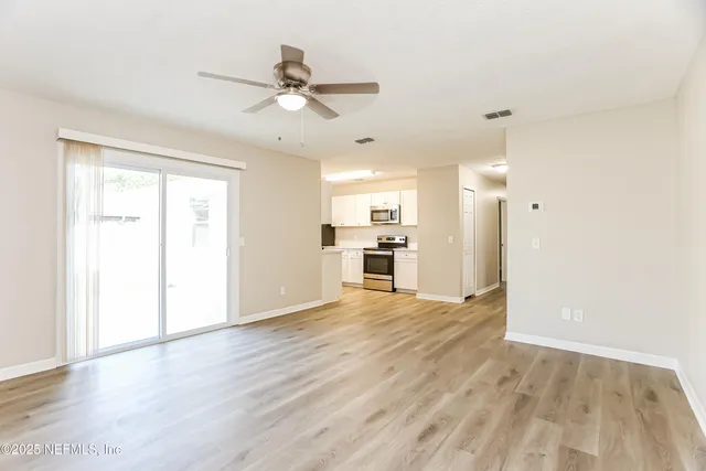 a view of a kitchen with a sink and wooden floor