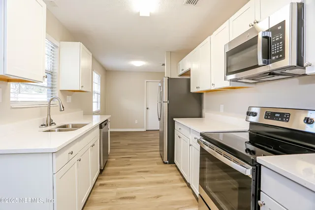 a kitchen with a sink stove and microwave