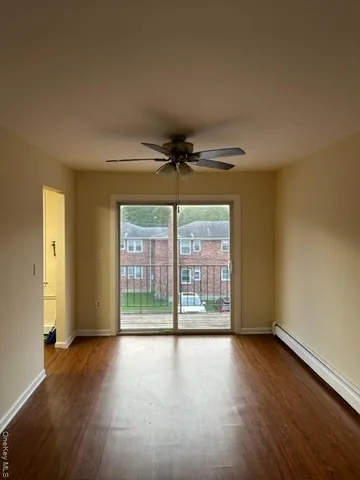 a view of a livingroom with wooden floor and a ceiling fan