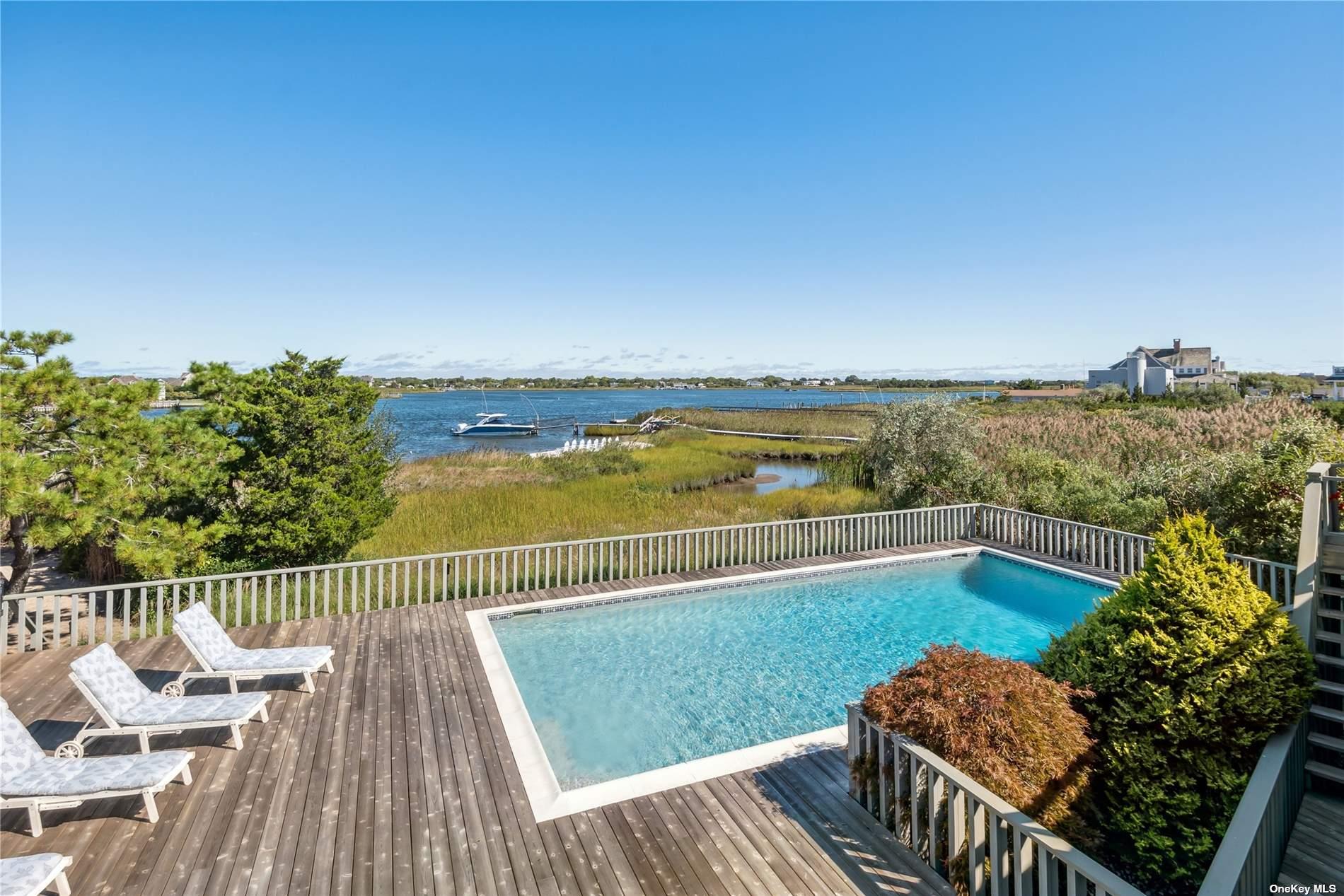 218 Dune Road Westhampton Beach, NY 11978 - Photo 1 of 1 a view of a chairs and table on the wooden deck