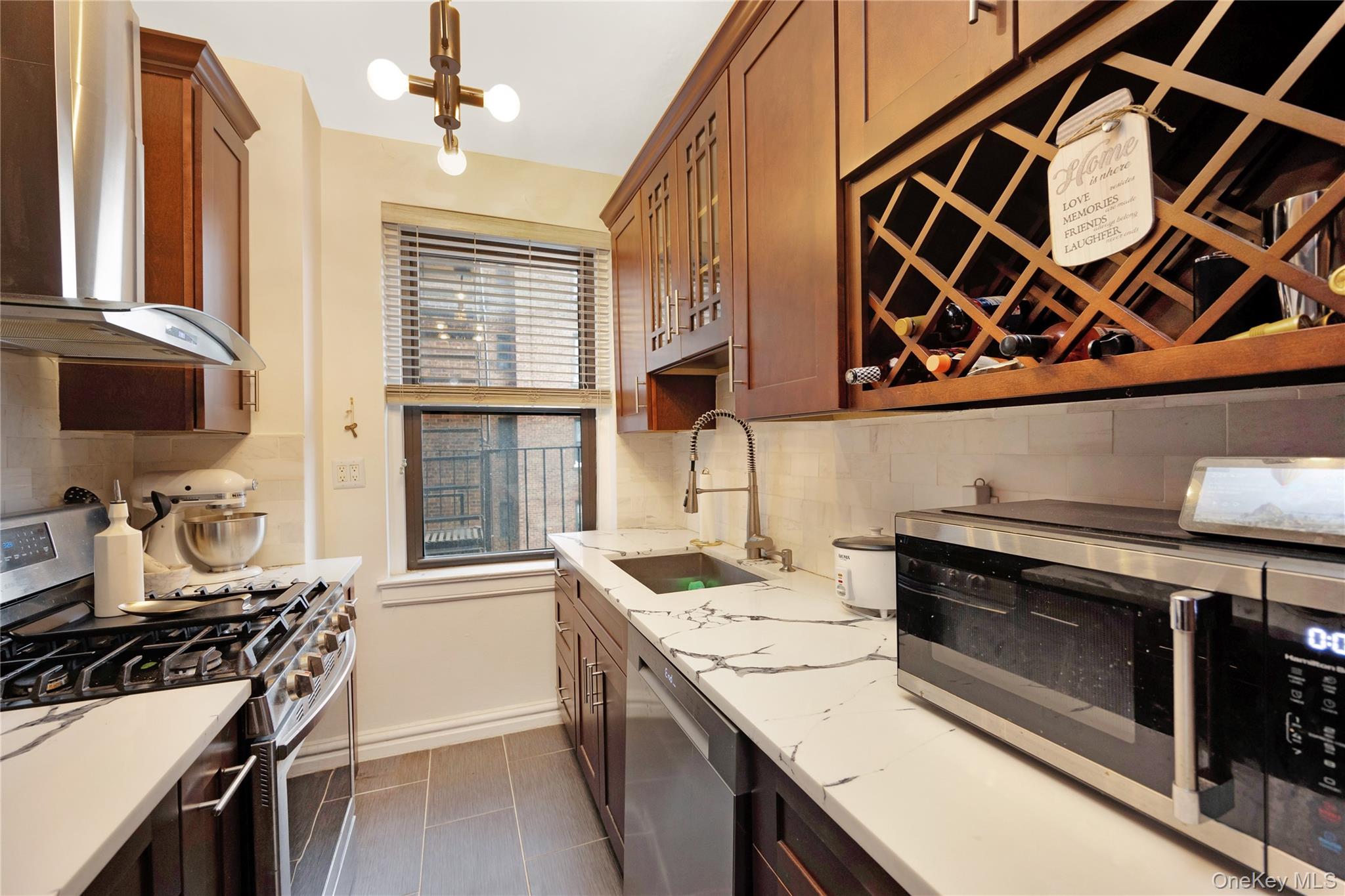 Kitchen featuring stainless steel appliances, decorative backsplash, sink, and quartz counters