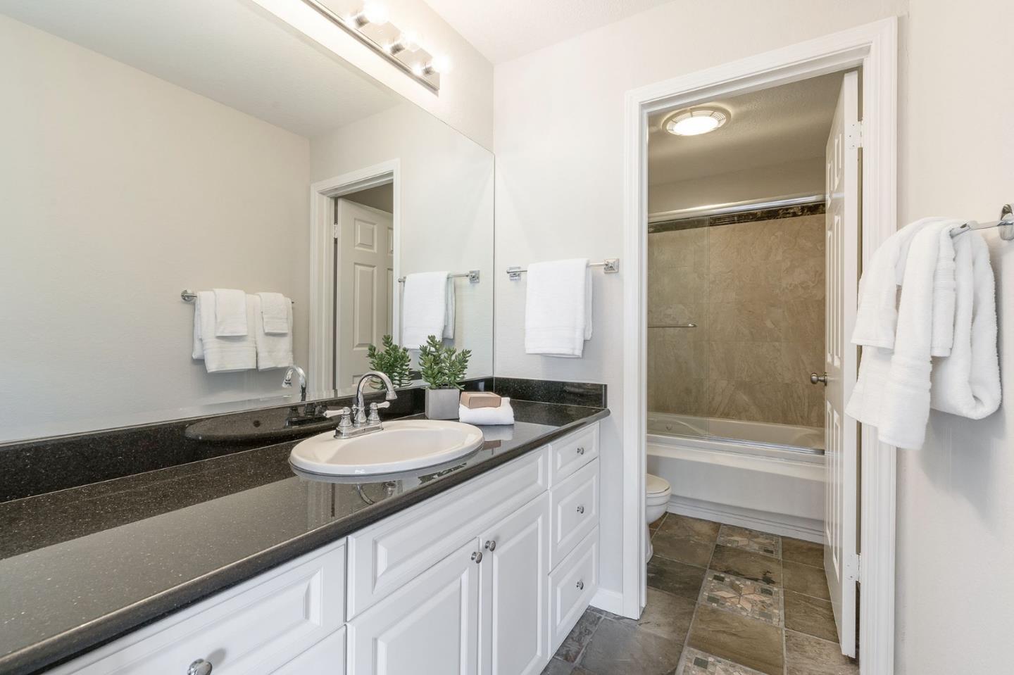 33 Park Road, Unit 13 Burlingame, CA 94010 - Photo 31 of 43 a bathroom with a sink and a mirror with bathtub