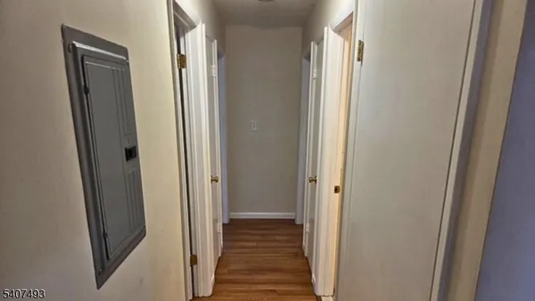 a view of a hallway with wooden floor and staircase