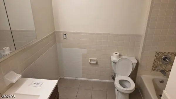 a white toilet sitting next to a shower