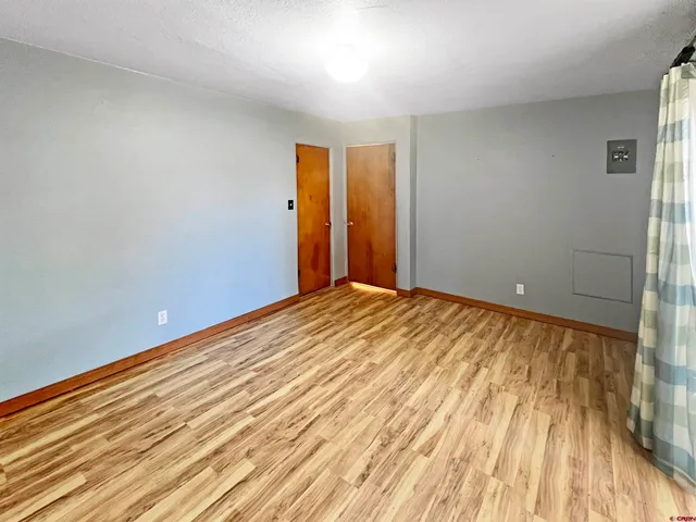 a view of a room with wooden floor
