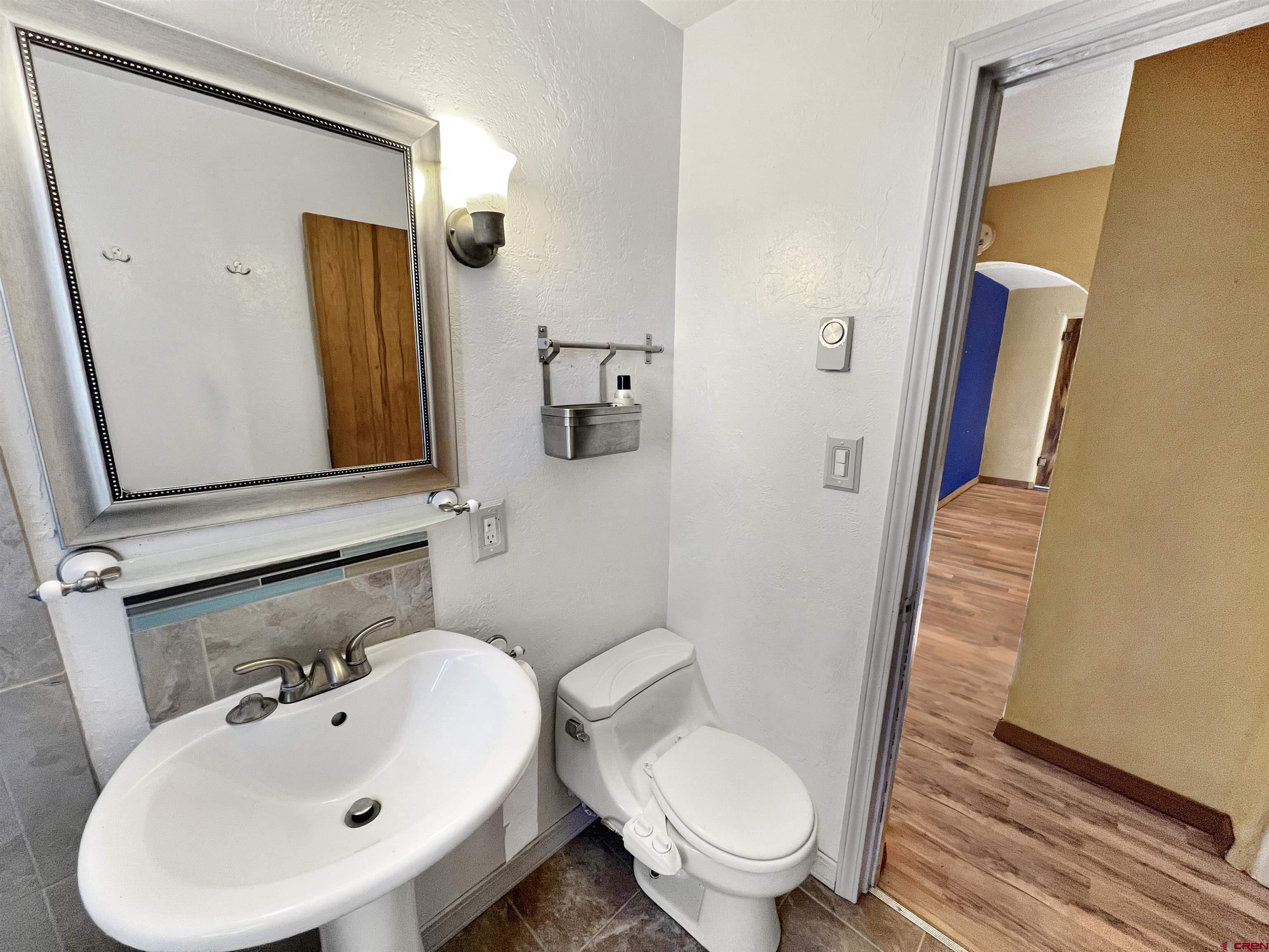 112 North Adams Street Cortez, CO 81321 - Photo 14 of 20 a bathroom with a sink and mirror with toilet