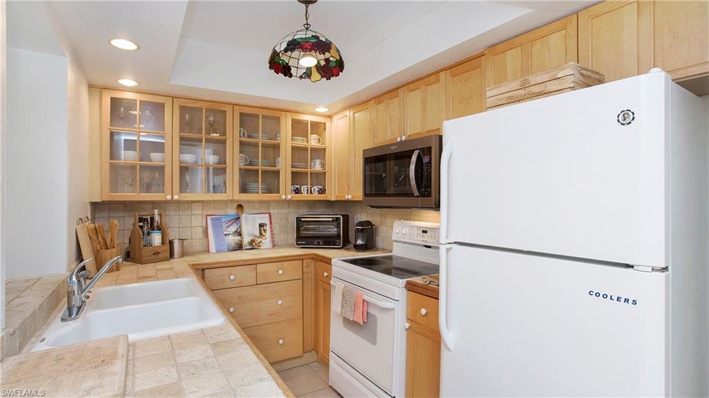 1560 Blue Point Avenue, Unit 3 Naples, FL 34102 - Photo 18 of 27 a kitchen that has a lot of cabinets and wooden floor