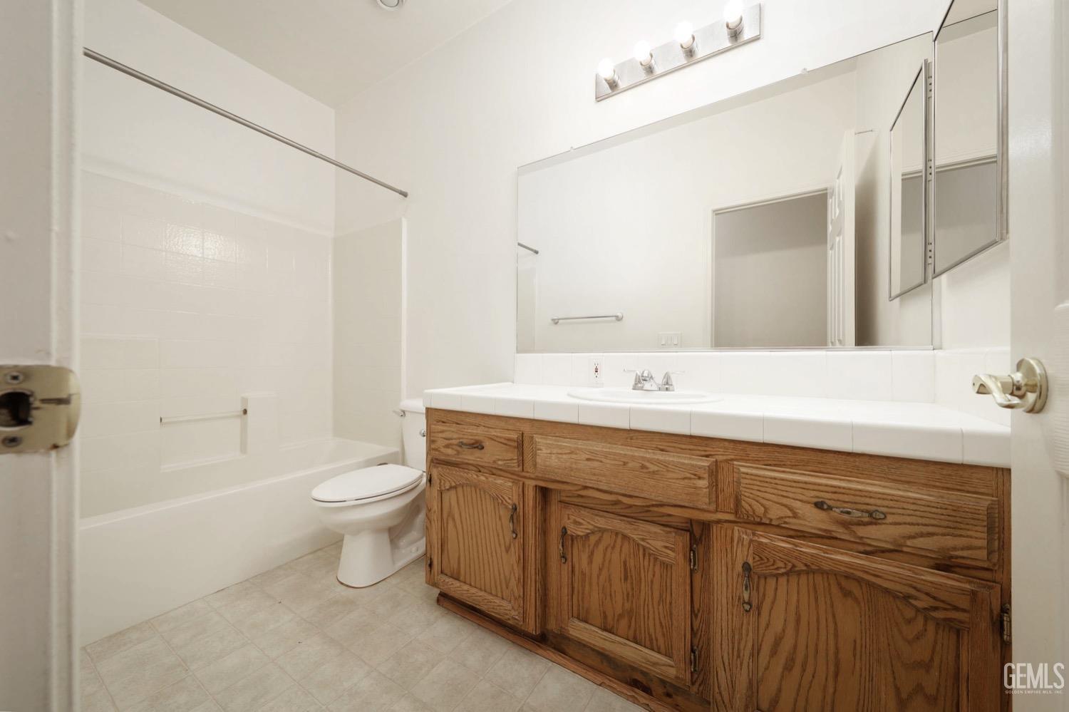 Undisclosed Address Bakersfield, CA 93312 - Photo 19 of 38 a bathroom with a double vanity sink a toilet and a bathtub