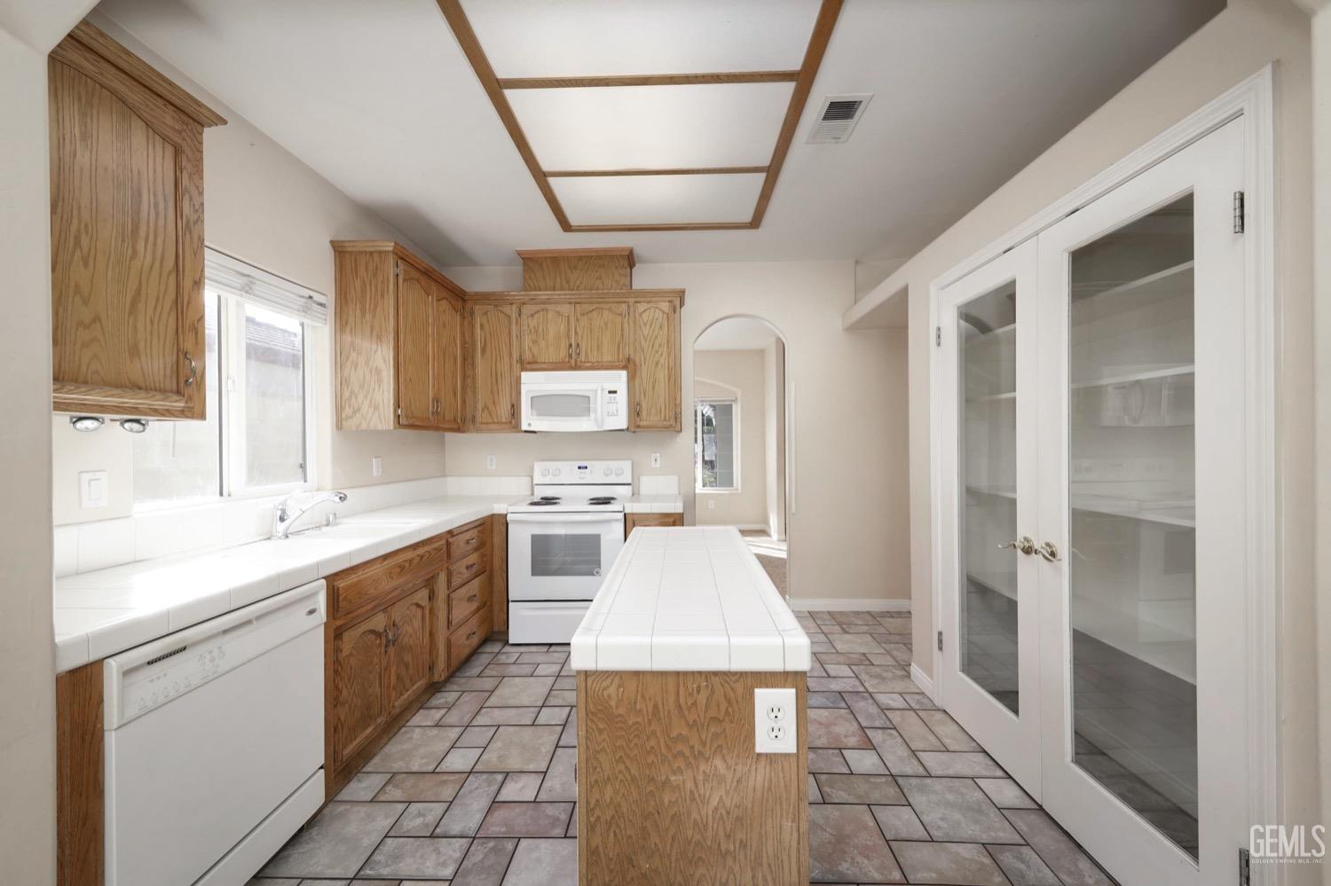 Undisclosed Address Bakersfield, CA 93312 - Photo 7 of 38 a large white kitchen with stainless steel appliances granite countertop a sink and cabinets