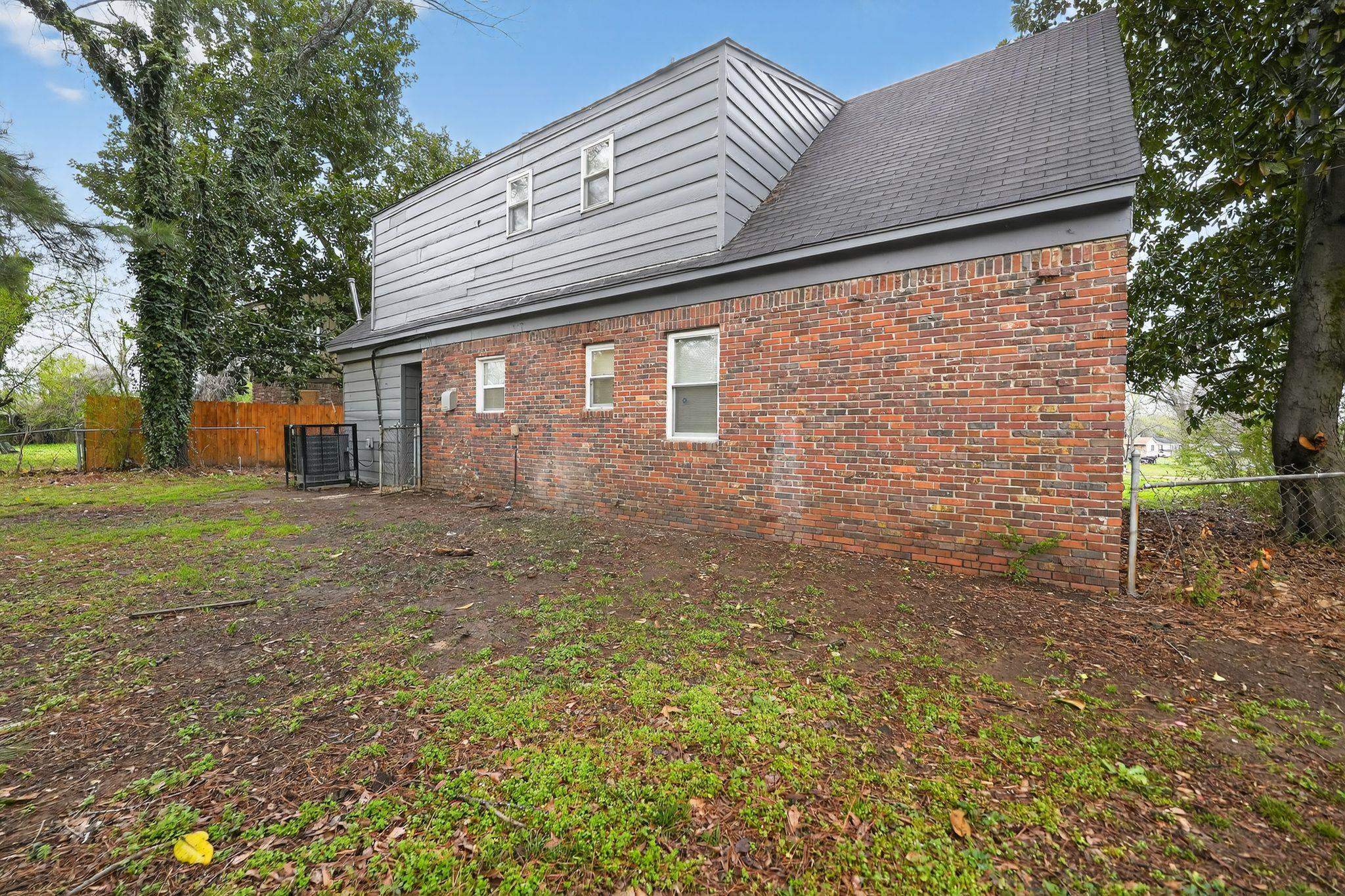 4646 Applegate Road Memphis, TN 38109 - Photo 26 of 37 a backyard of a house with large trees and brick walls