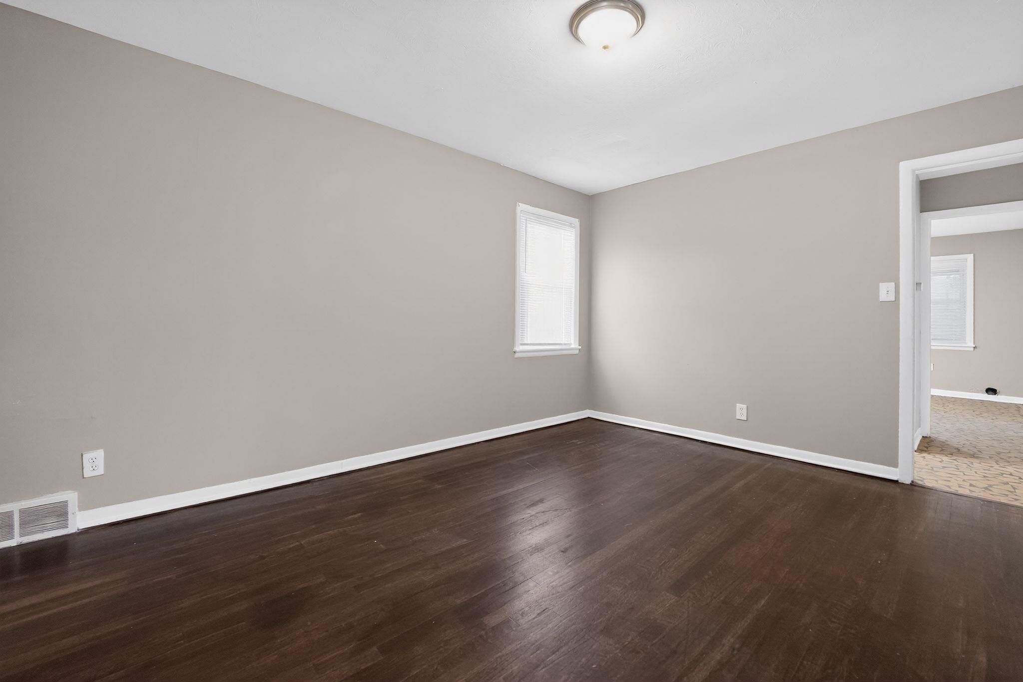 4646 Applegate Road Memphis, TN 38109 - Photo 4 of 37 a view of an empty room with wooden floor and a window