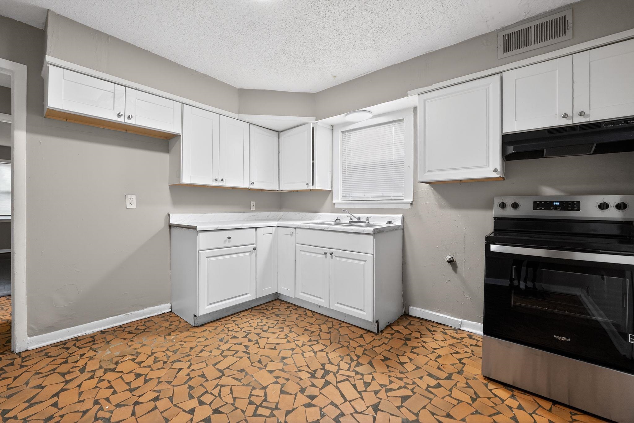 4646 Applegate Road Memphis, TN 38109 - Photo 6 of 37 a kitchen with a stove a sink and a microwave