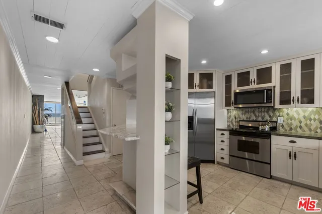 a kitchen with stainless steel appliances granite countertop a refrigerator and a sink