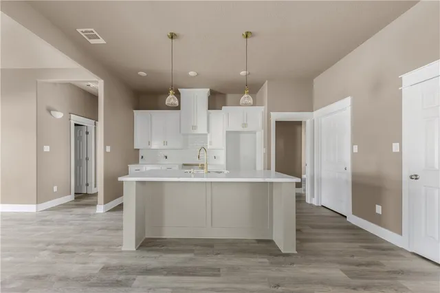a view of kitchen with stainless steel appliances granite countertop cabinets and wooden floor