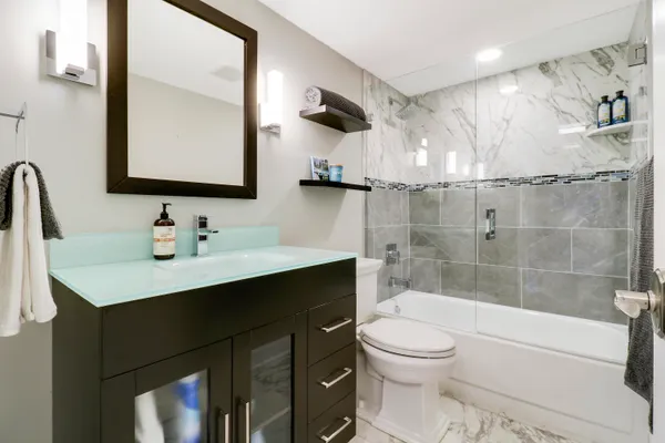 a bathroom with a sink a toilet and shower