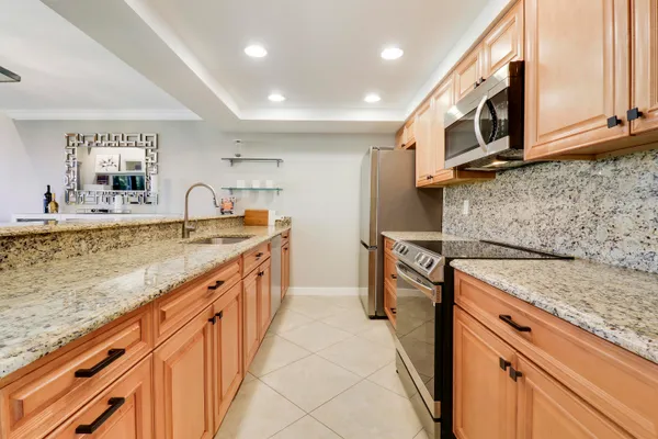 a kitchen with stainless steel appliances granite countertop a sink stove and cabinets