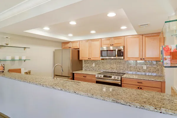 a large kitchen with kitchen island granite countertop a sink and a stove top oven with granite countertops