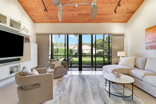 a living room with furniture tv and a floor to ceiling window