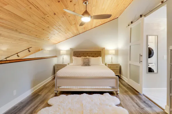 a bedroom with a bed and a large mirror with window