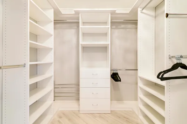 a view of walk in closet with empty racks