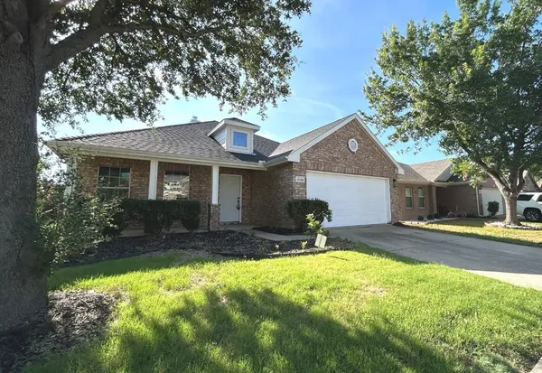 a front view of a house with a yard and tree