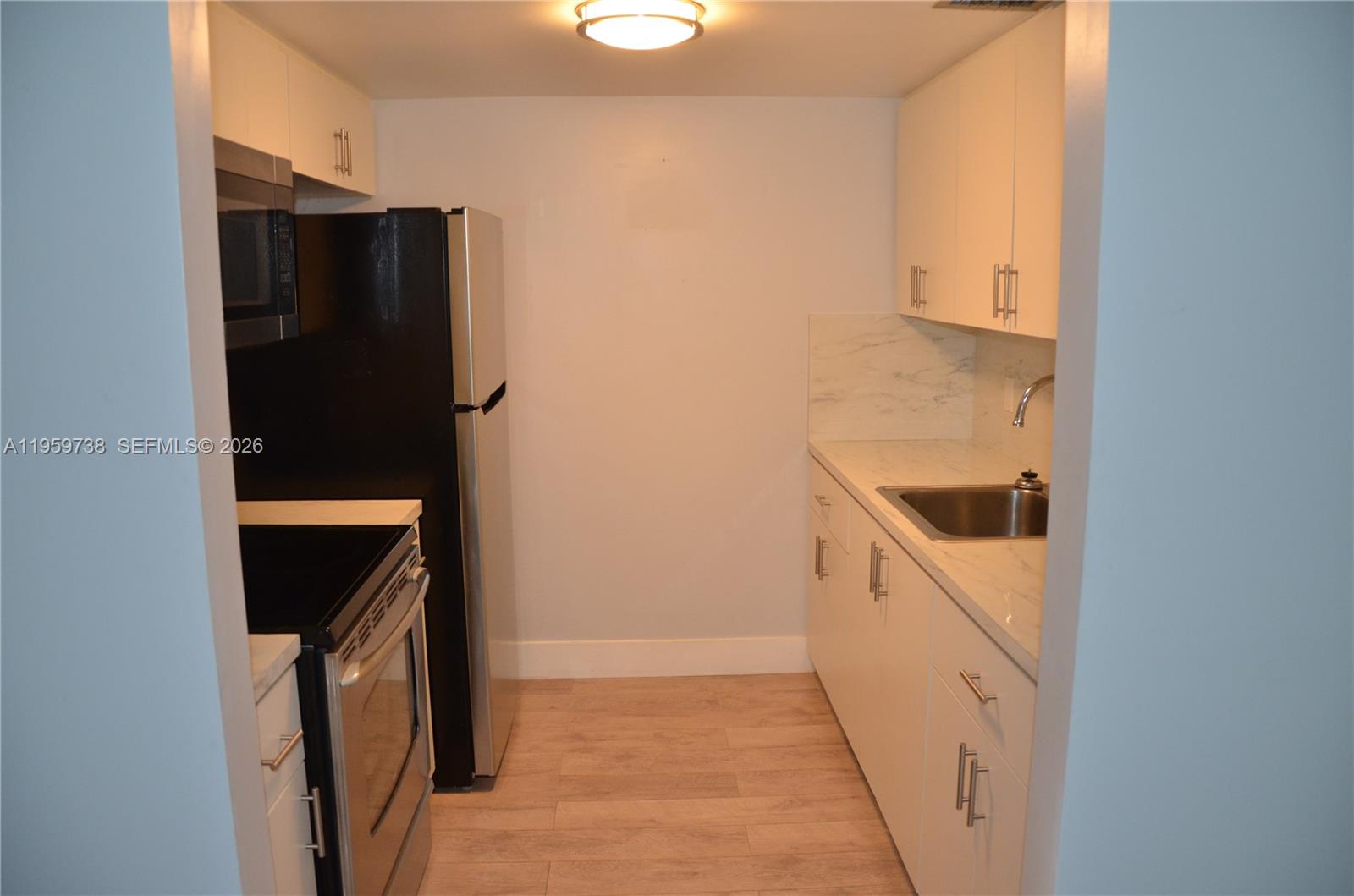 13475 Southwest 9th Street, Unit 407A Pembroke Pines, FL 33027 - Photo 4 of 15 a kitchen with a refrigerator and a stove