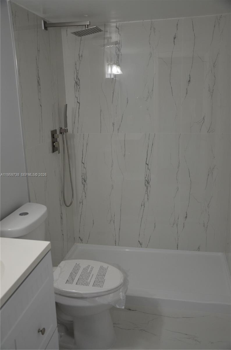 13475 Southwest 9th Street, Unit 407A Pembroke Pines, FL 33027 - Photo 7 of 15 a bathroom with a sink a toilet and shower