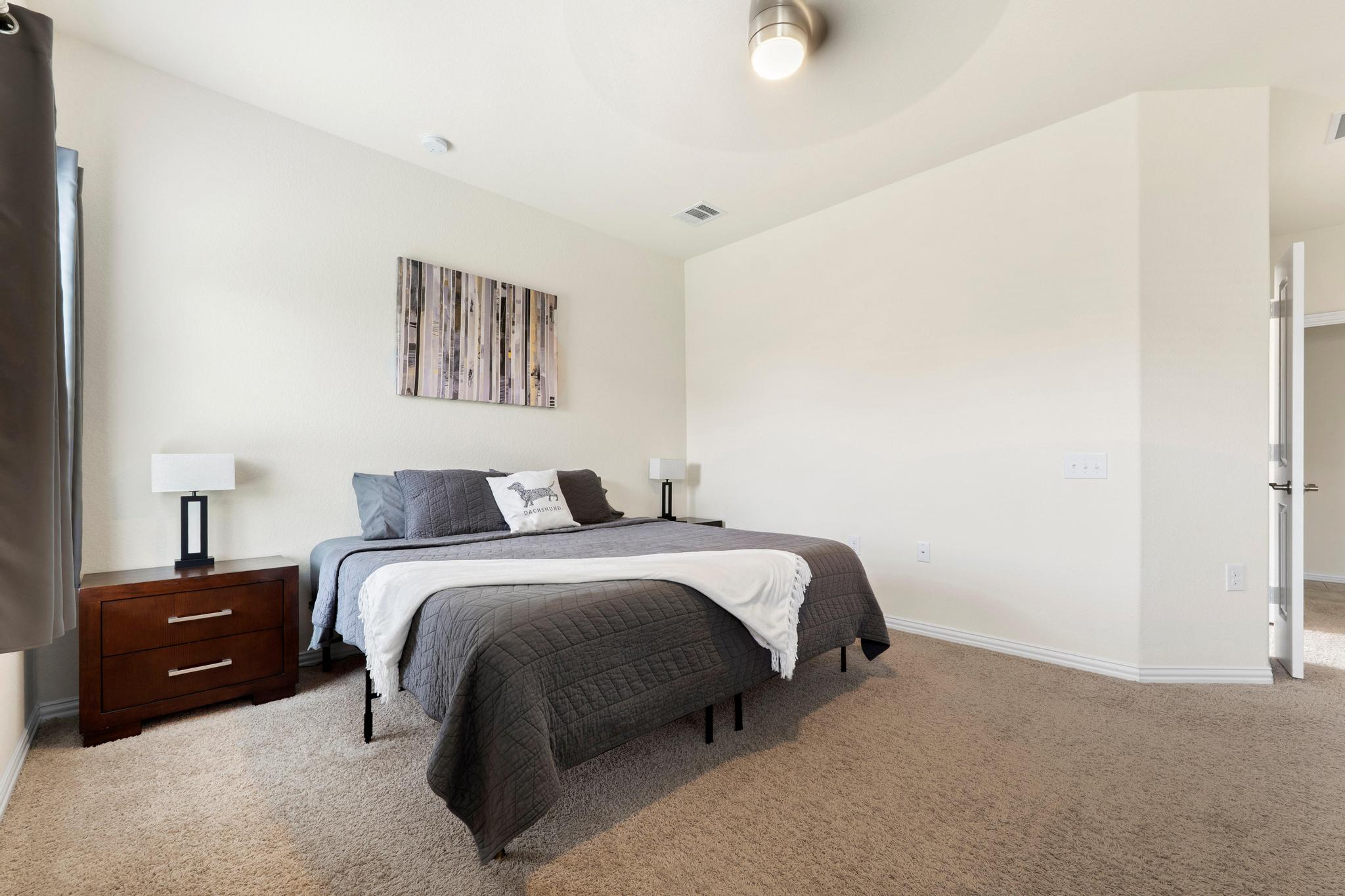 6905 Vail Ridge Street Austin, TX 78744 - Photo 14 of 39 Spacious primary suite featuring neutral-toned walls and ceiling fan
