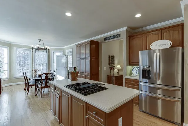 a kitchen with stainless steel appliances granite countertop a refrigerator a stove and a wooden floors