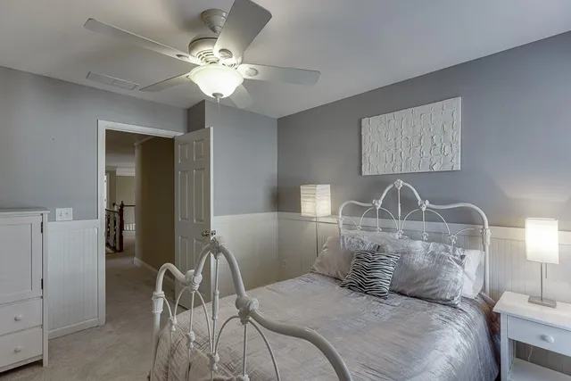 a bedroom with a bed a mirror and a window