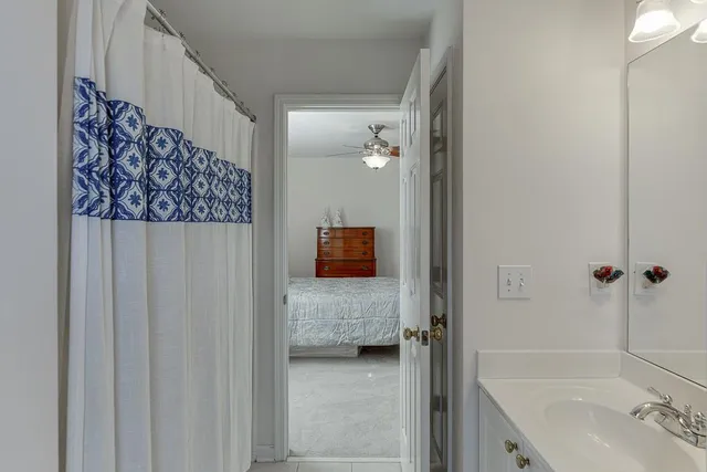 a view of a livingroom with a chandelier fan and windows