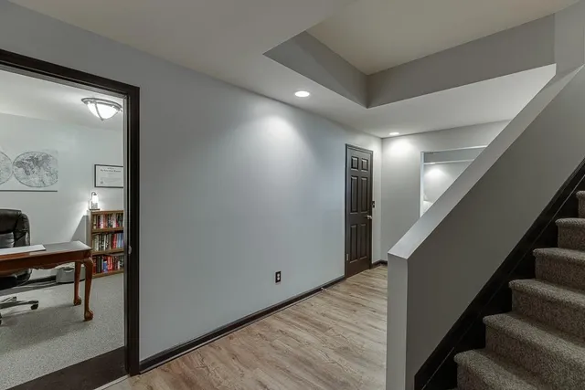 an aerial view of a residential houses with outdoor space and trees all around