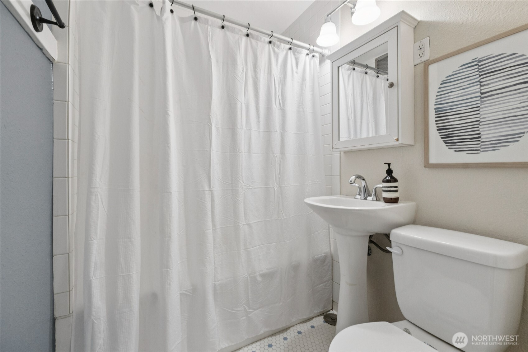 905 Northeast 43rd Street, Unit 108 Seattle, WA 98105 - Photo 17 of 28 a bathroom with a sink a toilet and shower curtain
